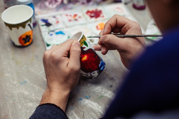 Pintura maestra en un vaso de plástico