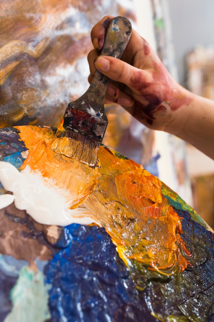 Foto gratuito pintura de la mano de la persona con pintura desordenada y pincel.
