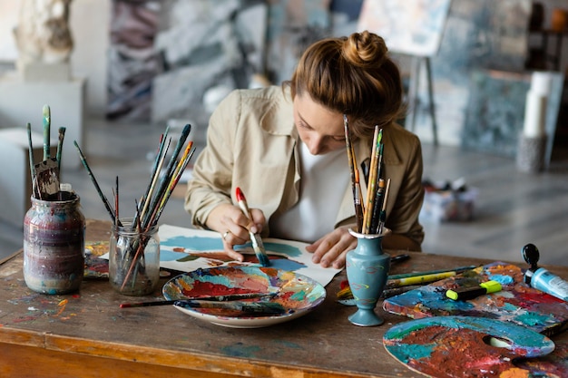 Pintura de mujer de tiro medio en el escritorio