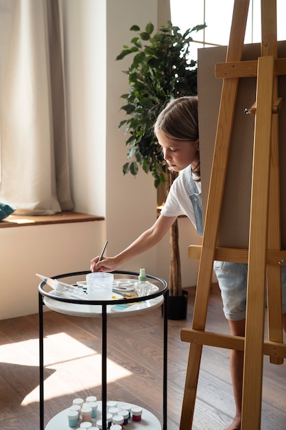 Pintura de niña de tiro completo en casa