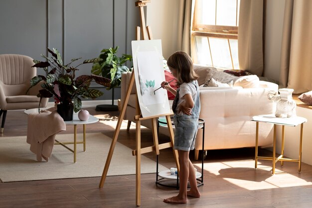 Pintura de niña de tiro completo con pincel