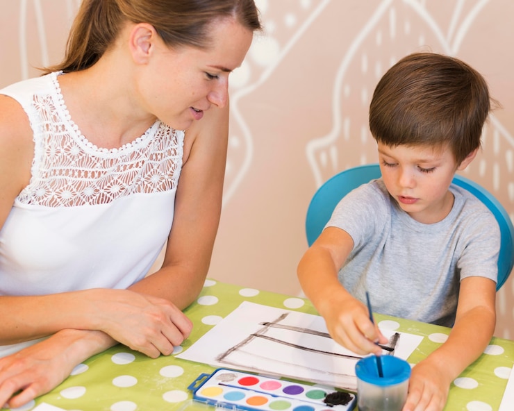 Foto gratuito pintura de niño de tiro medio en la mesa
