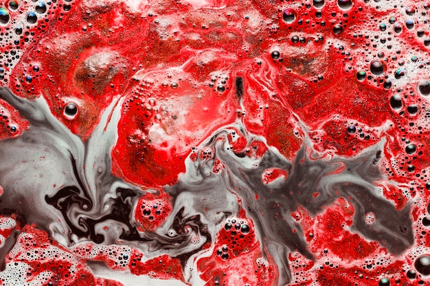 Pintura roja que se mezcla con agua sucia