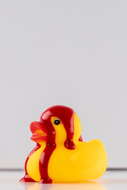 Pintura roja sobre pato de goma amarillo