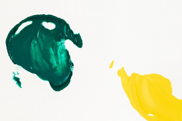 Pintura verde y amarilla manchada sobre fondo blanco.