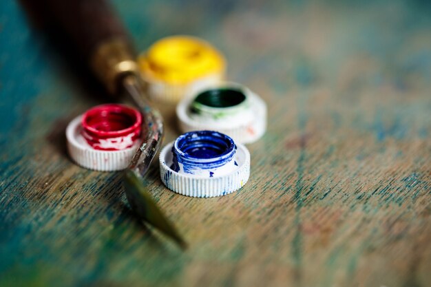 Pinturas al óleo y espátula sobre pared de madera