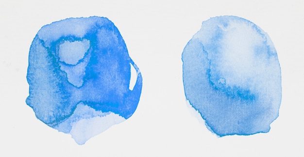 Pinturas azules en forma de círculos sobre papel blanco.