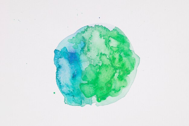 Pinturas verdes y aguamarinas en forma de círculo sobre papel blanco.