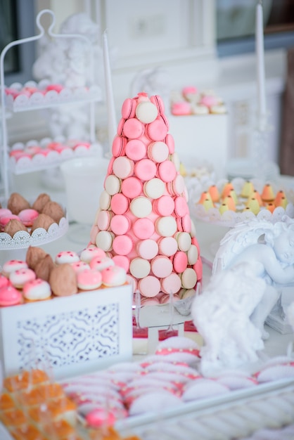 Foto gratuita pirámide de macarrones rosados ​​y blancos se encuentra en la barra de caramelo