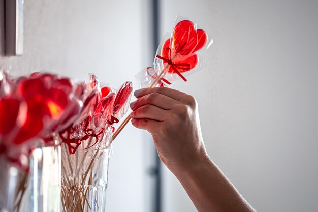 Piruletas rojas en forma de corazón en el mostrador de una tienda de golosinas