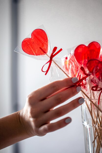 Piruletas rojas en forma de corazón en el mostrador de una tienda de golosinas