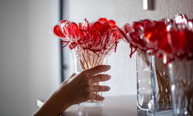 Piruletas rojas en forma de corazón en el mostrador de una tienda de golosinas