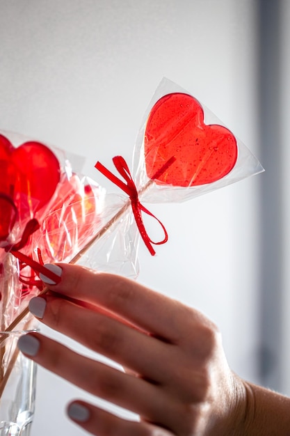 Piruletas rojas en forma de corazón en el mostrador de una tienda de golosinas