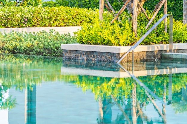 Piscina al aire libre con sillón con sombrilla y salón para viajes de placer.