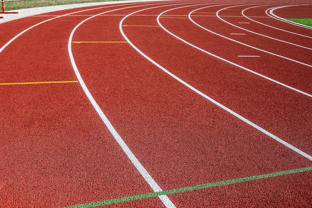 Pista de carrera. Cinta de correr roja en el campo deportivo. Estadio deportivo al aire libre