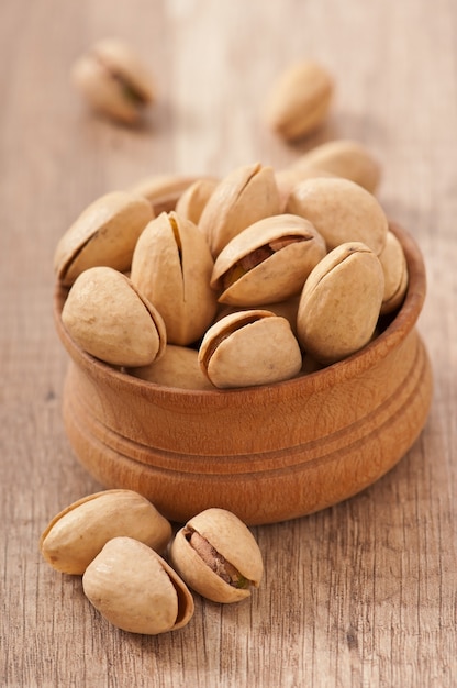 Pistachos agrietados y secos en un tazón de madera