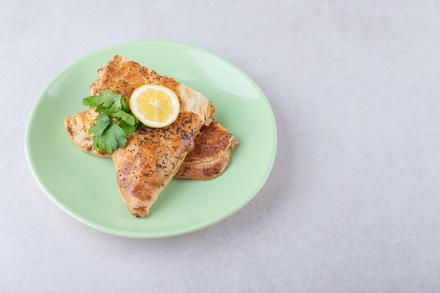 Pita de Ramadán con rodaja de limón en un plato, sobre el mármol.