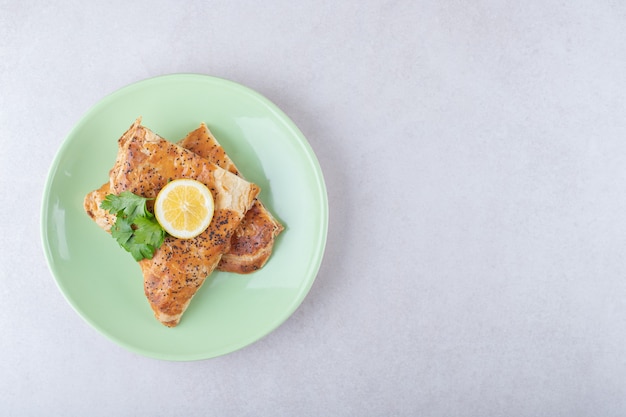 Pita de Ramadán con rodaja de limón en un plato, sobre el mármol.