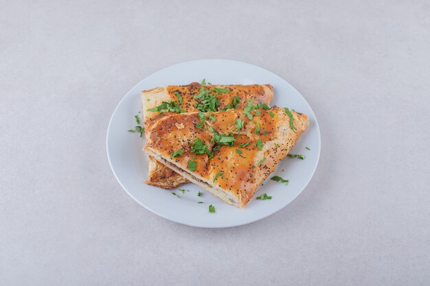 Pita de sésamo con perejil picado en plato, sobre el mármol.