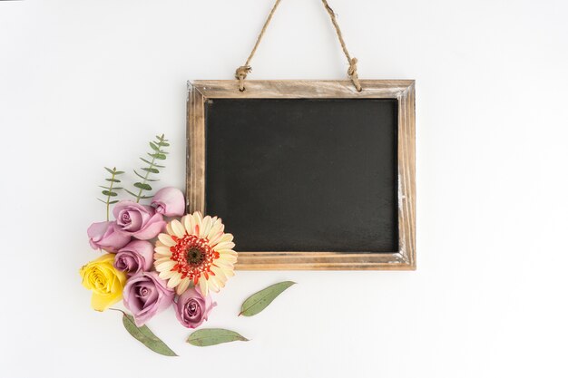 Pizarra en blanco con flores hermosas