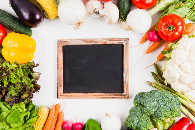 Pizarra enmarcada por verduras frescas