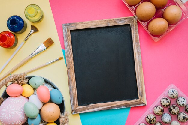 Pizarra y huevos de Pascua con pinceles