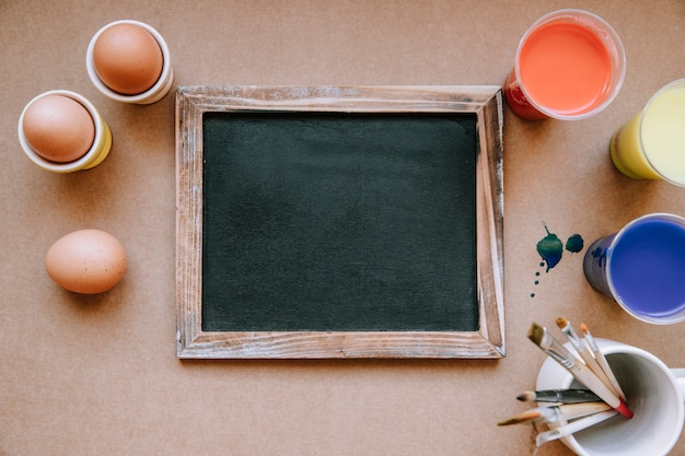 Foto gratuita pizarra y huevos preparados para pintar