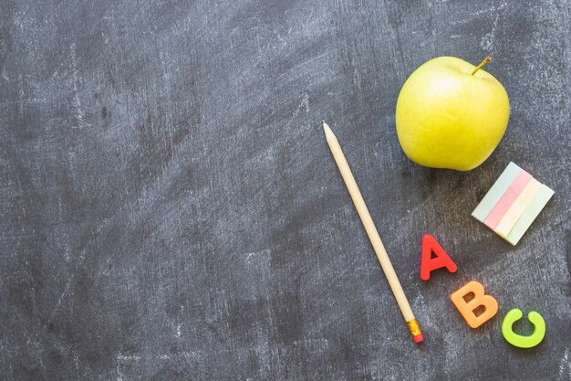 Pizarra con letras del alfabeto de papelería y manzana