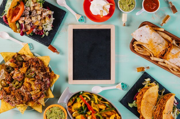 Pizarra en medio de la comida mexicana sobre fondo azul