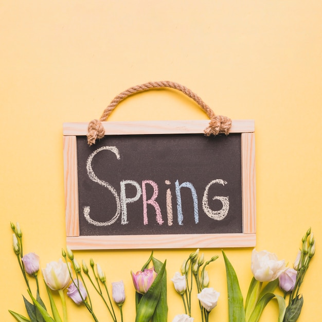 Foto gratuita pizarra con la primavera escribiendo sobre rosas