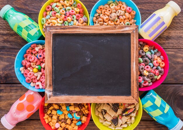 Pizarra sobre brillantes cuencos de cereales y botellas