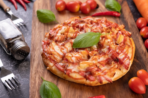 Foto gratuita pizza en bandeja de madera con tomate ají y albahaca.