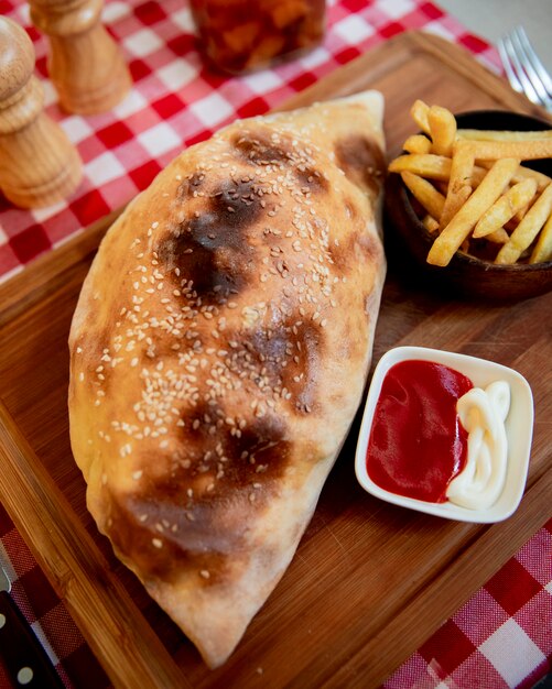 Pizza Calzone con papas fritas y salsa de tomate