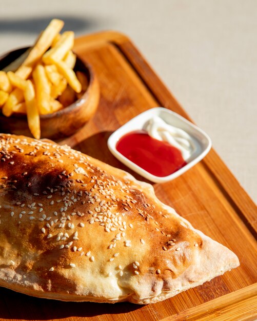 Pizza Calzone con papas fritas y salsa de tomate