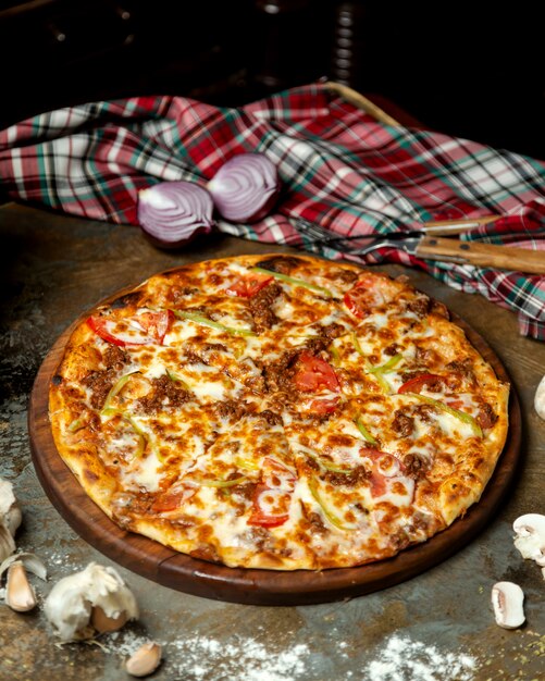 Pizza de carne con pimientos tomate y queso