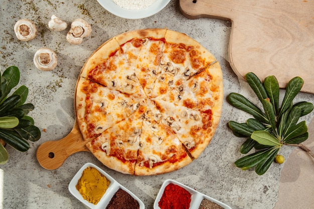 Pizza de champiñones con champiñones y especias sobre la mesa