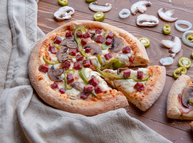 Pizza de champiñones en rodajas sobre la mesa de madera