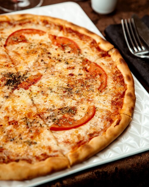 Pizza crujiente con queso y tomates.