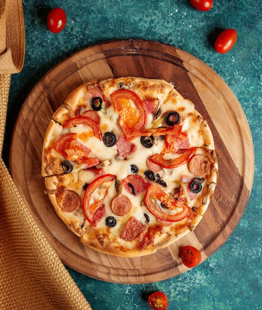 Foto gratuita pizza crujiente con tomates y aceitunas y salchichas