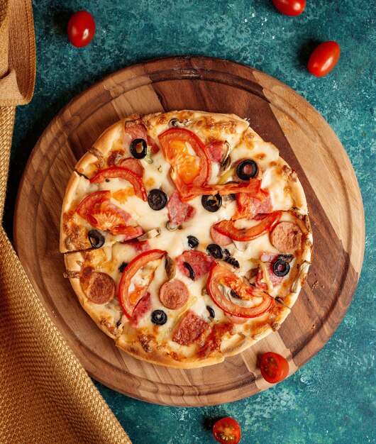 Pizza crujiente con tomates y aceitunas y salchichas