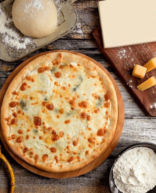 Foto gratuita pizza cuatro quesos sobre la mesa