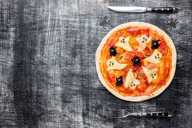 Pizza de Halloween con fantasmas y cubiertos