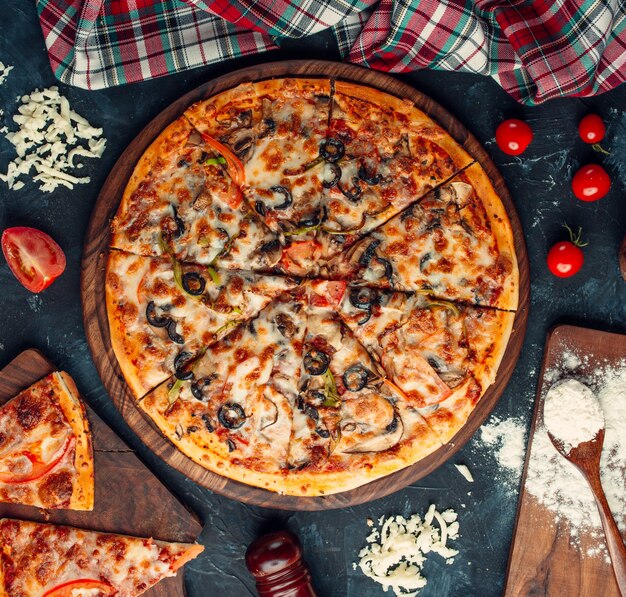 Pizza de ingredientes mixtos con queso y tomates.