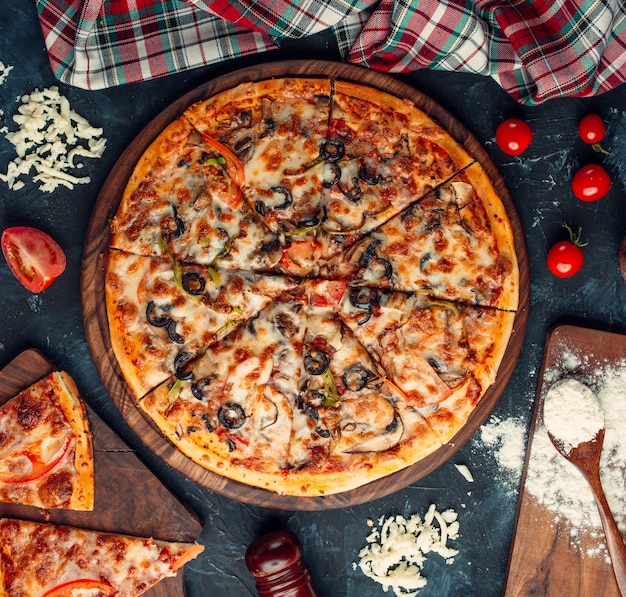 Pizza de ingredientes mixtos con queso y tomates.