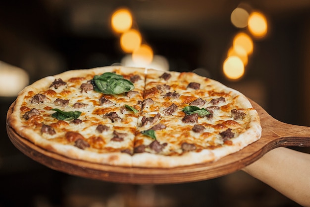 Pizza de ingredientes mixtos en una tabla de madera