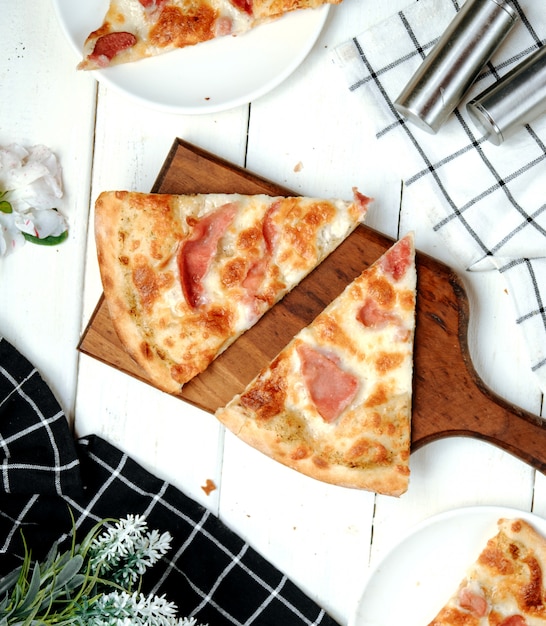 Foto gratuita pizza con jamón sobre la mesa