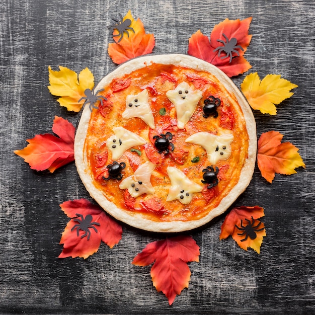 Pizza malvada de halloween rodeada de hojas