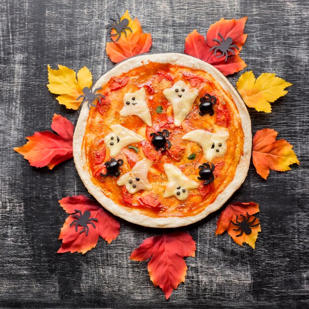 Pizza malvada de halloween rodeada de hojas