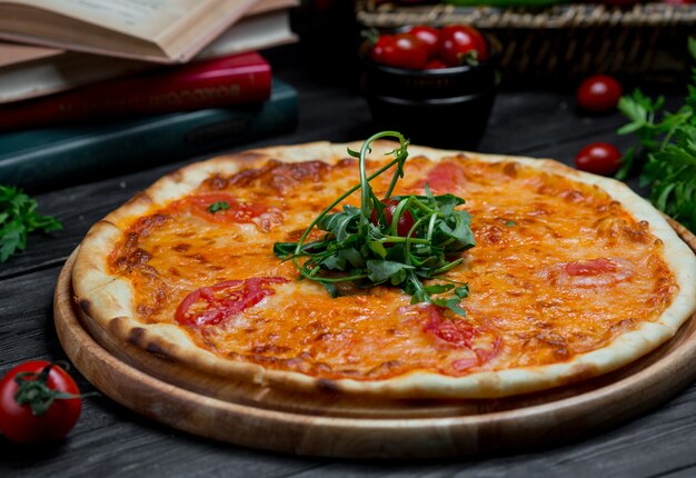 Pizza margarita con salsa de tomate y queso mozarella servida con ensalada verde