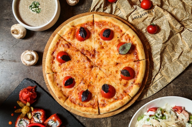 Pizza margarita en la tabla de madera queso tomate albahaca vista superior